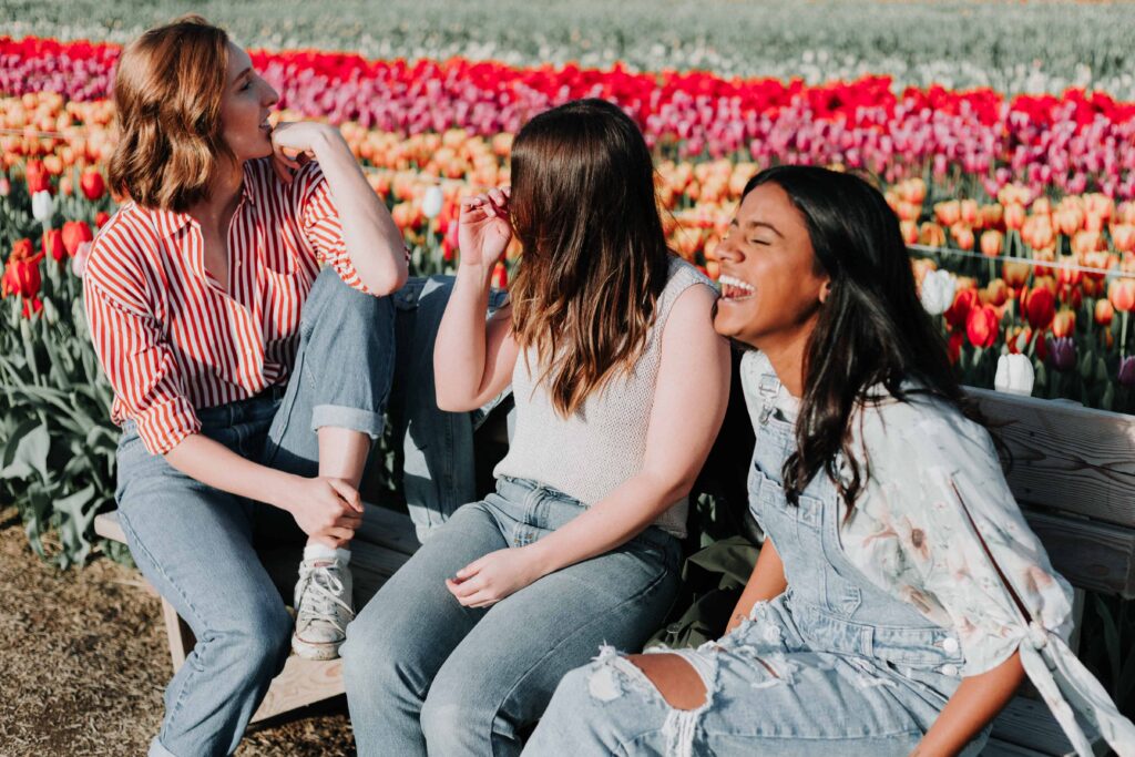 three friends talking to each other and laughing