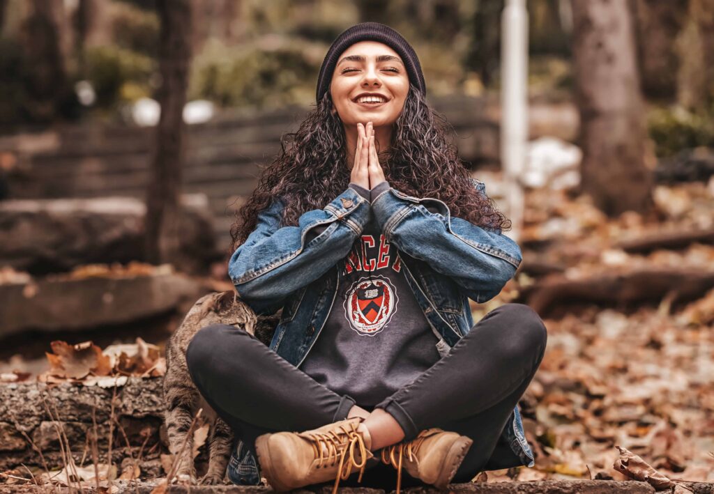 a woman sitting with a smile meditating and doing a breathing technique