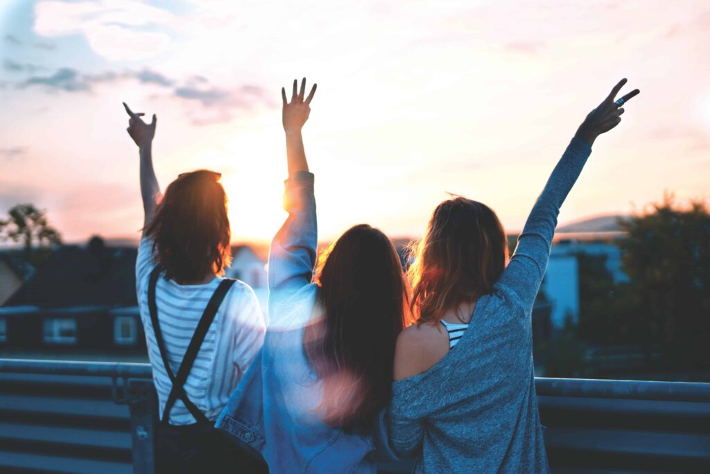 Three friends happy at sunset